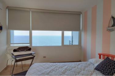 Gourmet kitchen with granite counters, stainless appliances, and white cabinets in beachfront penthouse Coronado