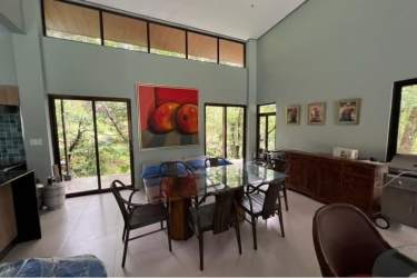 Bright dining space with artistic décor, large windows and open views in mountain retreat in Panama