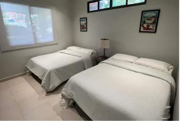 Bedroom featuring two beds, tile floors, and large window with nature view in mountain house Panama