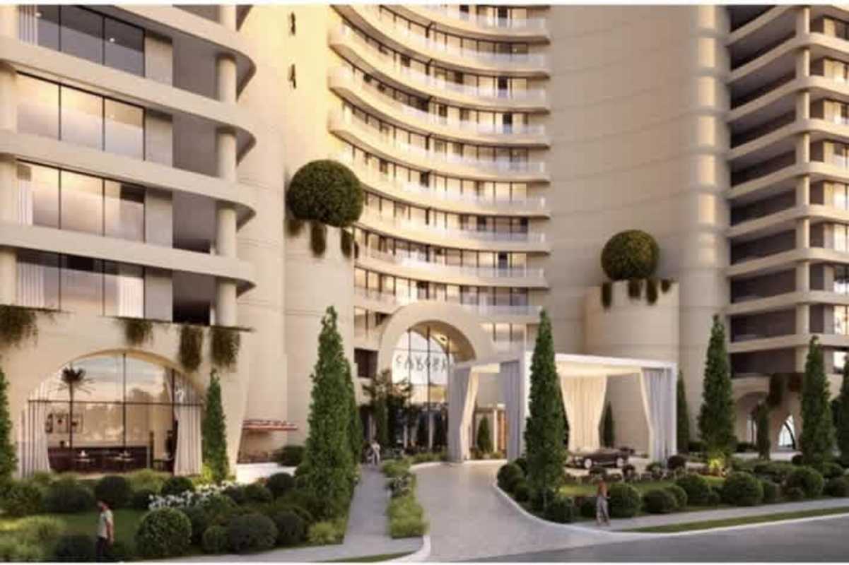 Tall seaside condominium tower with curved balconies and rooftop garden