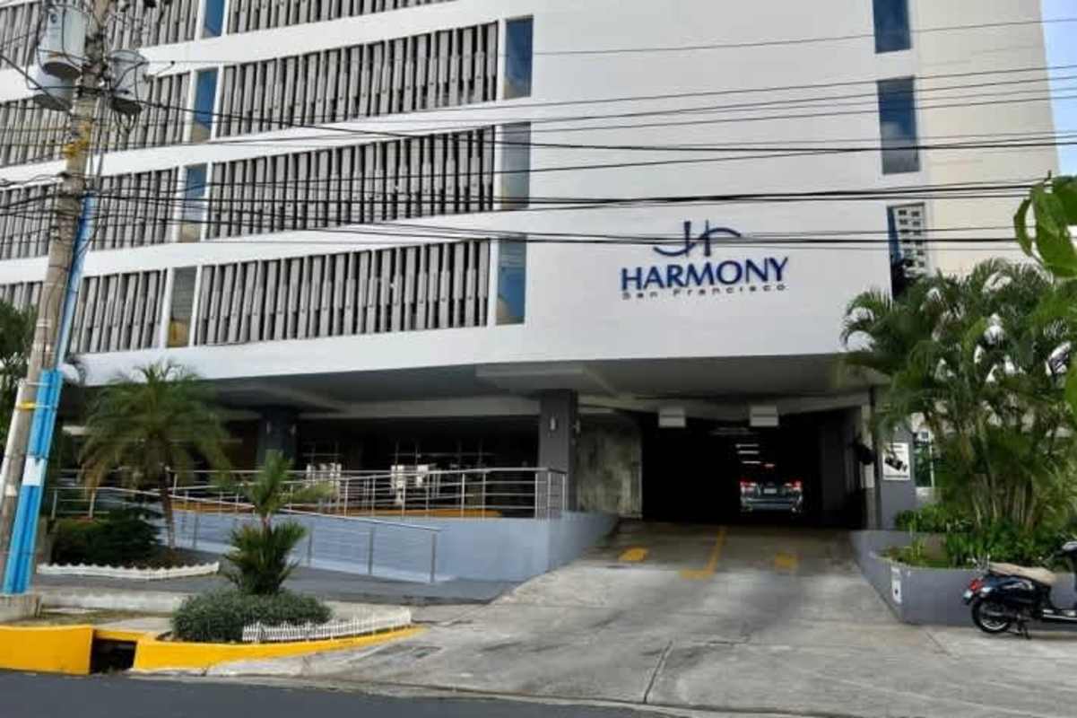 Modern multi-story PH Harmony Tower with parking entrance and landscape in Panama City