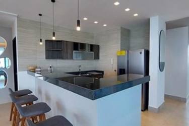 Contemporary kitchen with granite countertop and breakfast bar at Ocean Waves Playa Malibú Panama