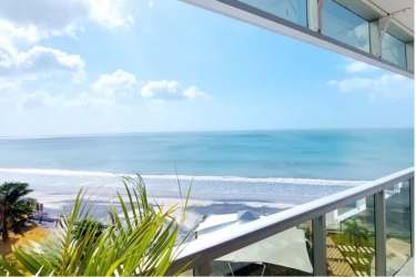 Ocean view private balcony with glass railing overlooking Playa Malibú waterfront at Ocean Waves