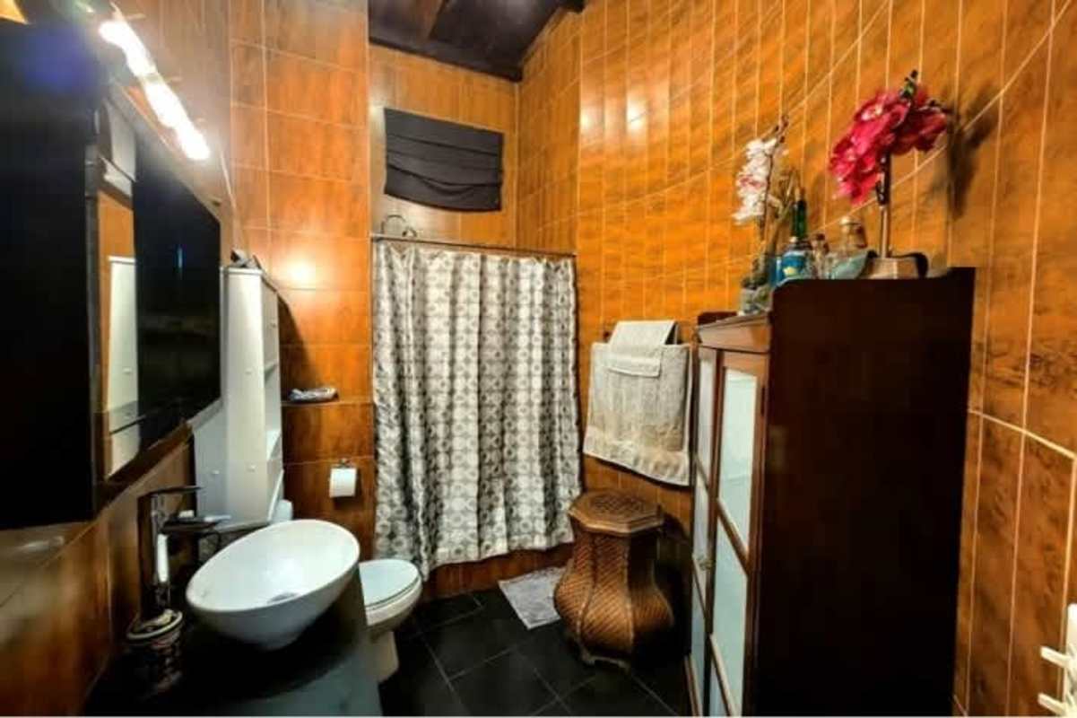 Remodeled bathroom with vessel sink, tiled walls, large mirror in Obarrio house Panama