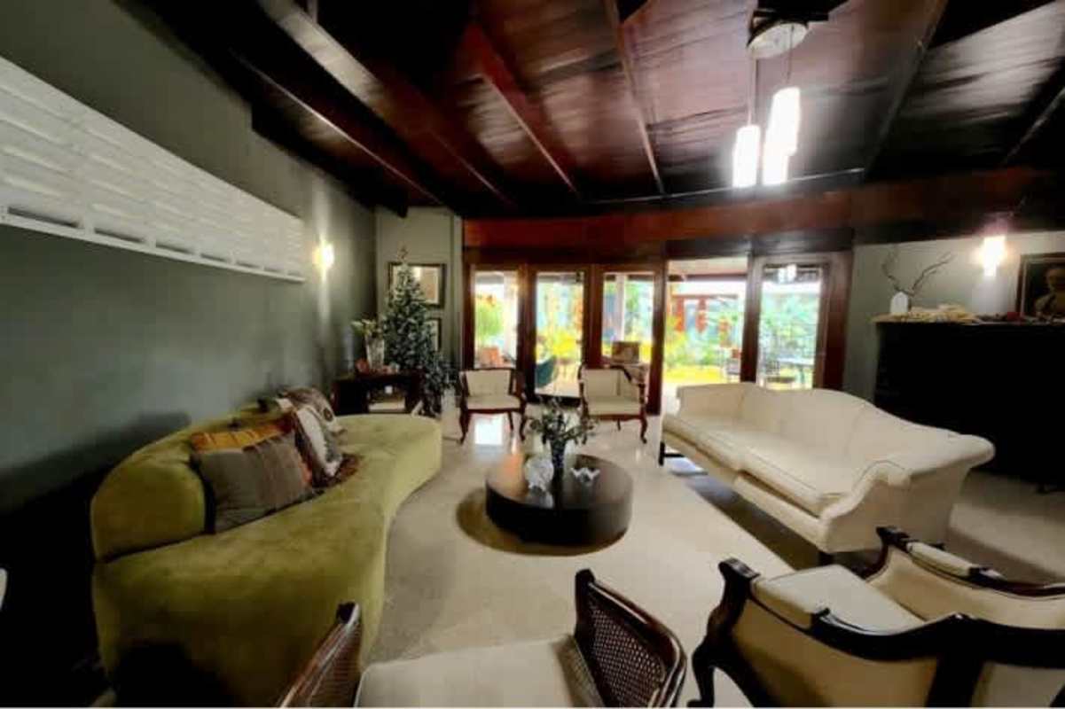 Spacious living room with wood ceilings, glass doors to patio, natural light in Obarrio home Panama City