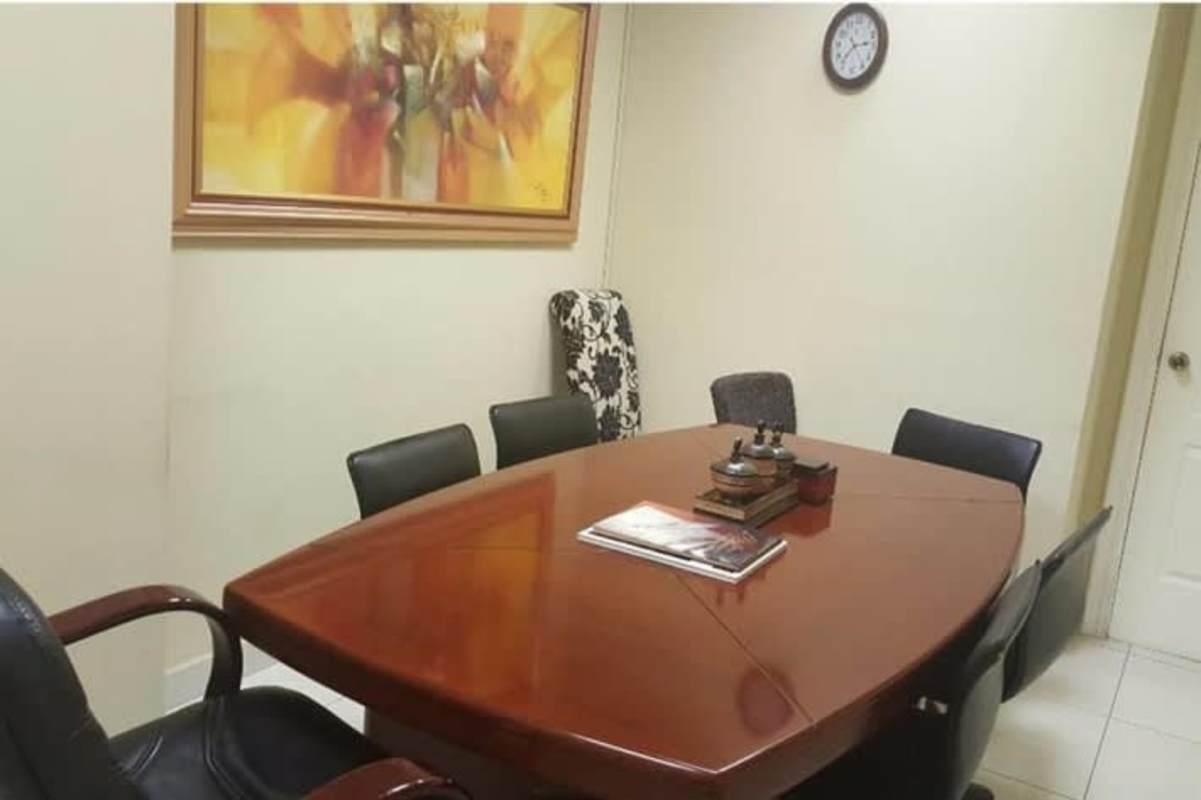 Conference room with table, chairs, wall art and clock PH Top Tower office for rent Panama