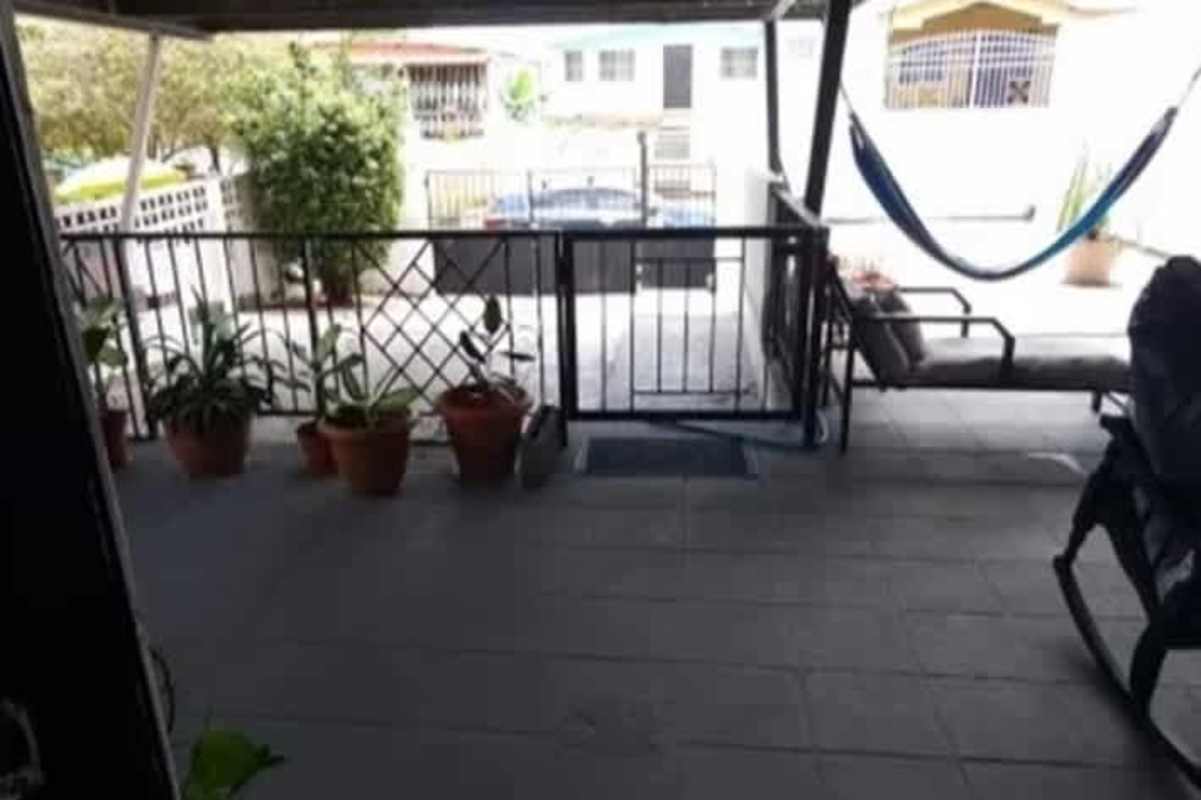 Bedroom with striped bedding, ceiling fan, dark accent wall in Don Bosco house Panama