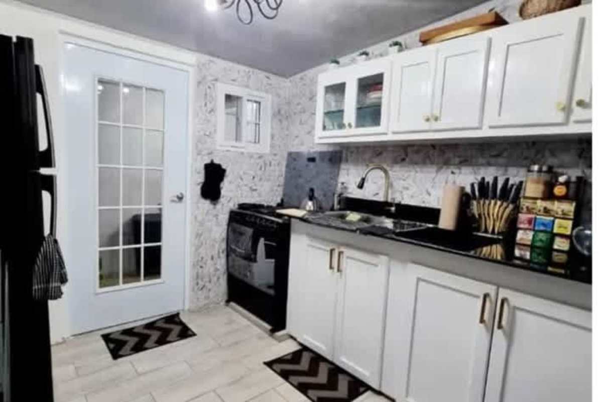 Bedroom with office desk, teal accent wall, ceiling fan and AC in Don Bosco house Panama