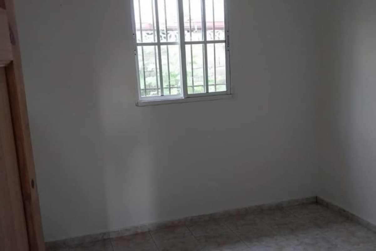 Second bedroom with tiled floor and window in house at Residencial Torremolinos Tocumen Panama