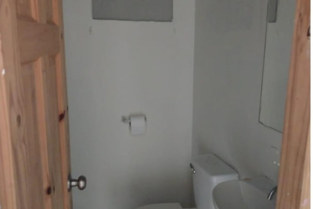 Compact bathroom with toilet, sink and mirror in affordable house Tocumen Panama