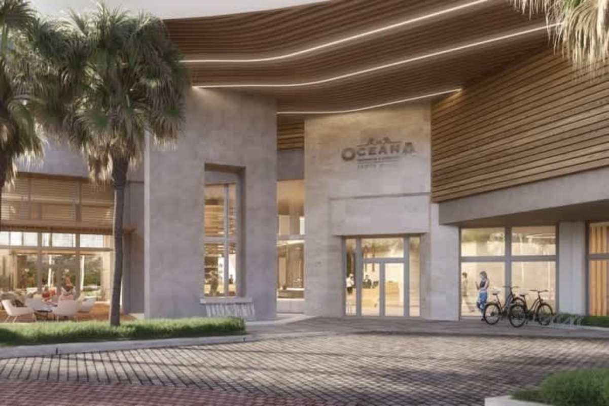 Elegant breezeway entrance with tall glass, wood details, palm landscaping at Oceana Santa Maria