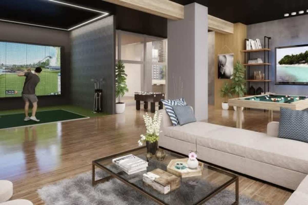 Modern clubhouse lounge featuring golf simulator, plush seating, game zone at Oceana Santa Maria Panama