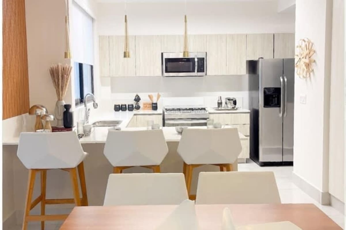 Living room with double-height ceiling, large windows, modern minimalist furniture Green City Panama