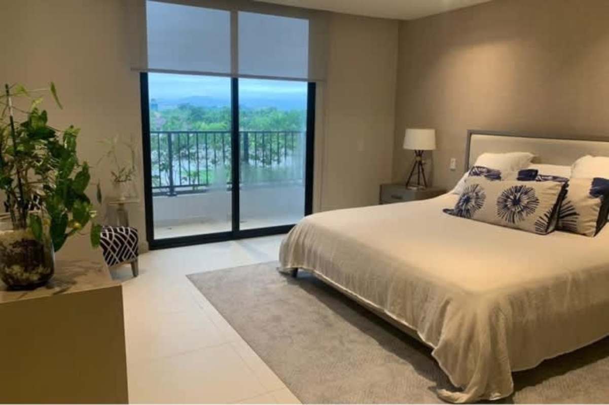 Master bedroom with large windows and ocean view balcony in Costa del Este apartment