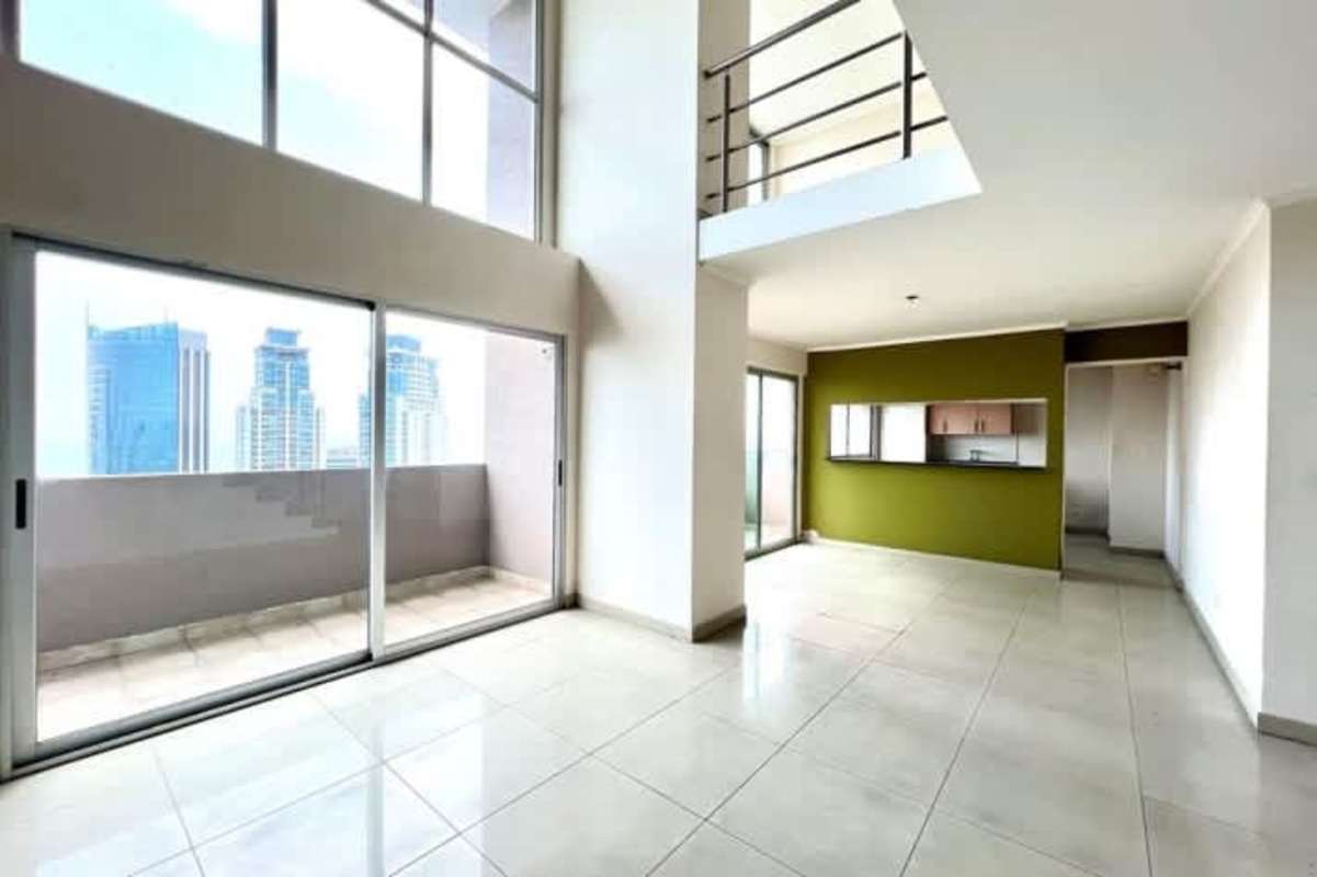 Living area large sliding glass doors to balcony blue accent wall panoramic view PH Sevilla Panama
