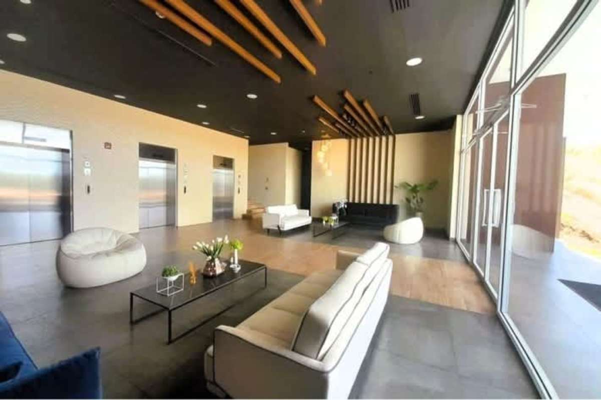 Modern lobby with multiple elevators and seating area in PH Country Heights Condado del Rey Panama City