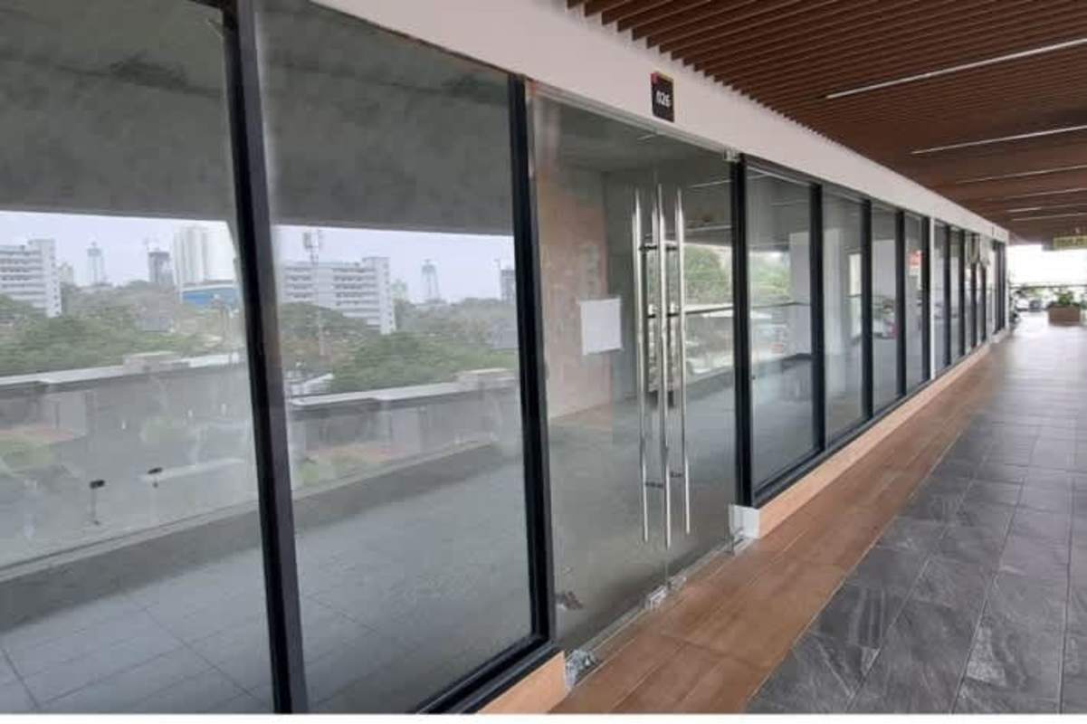 Glass entrance with tiled walkway and cityscape background in Greenwood District Plaza San Miguelito