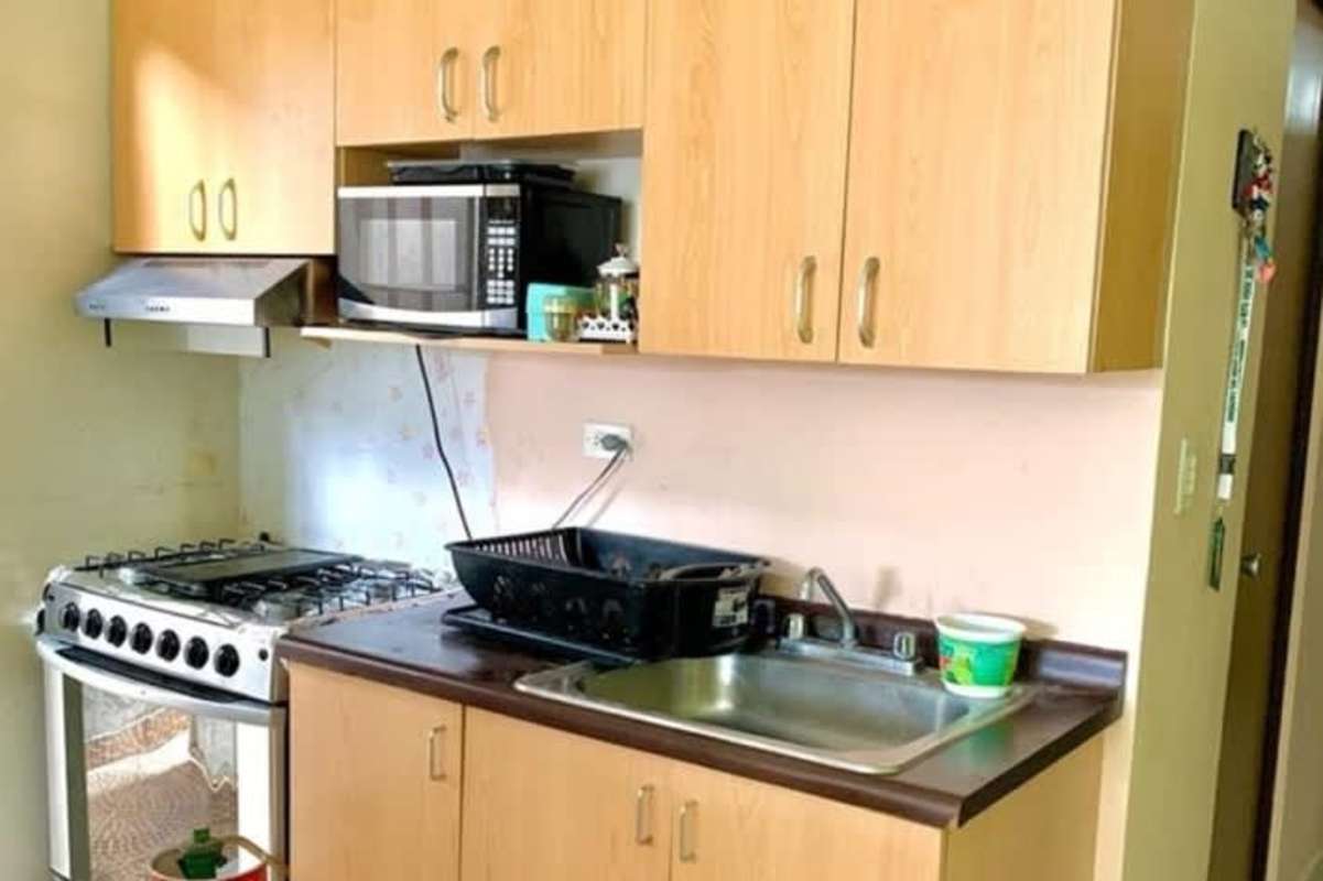 Compact kitchen with stove, microwave, light wood cabinets Parque Villa Lucia Panama