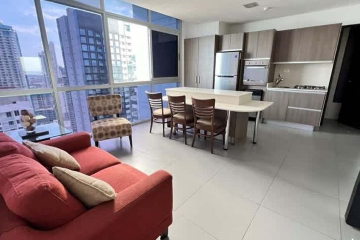 Bright living area with red sofa and balcony offering ocean city views in PH Colores de Bella Vista Panama