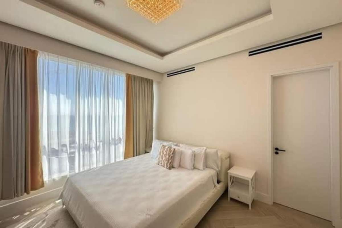 Spacious bedroom with large window, neutral tones, luxury finishes overlooking marina at Ocean Reef Punta Pacífica Panama