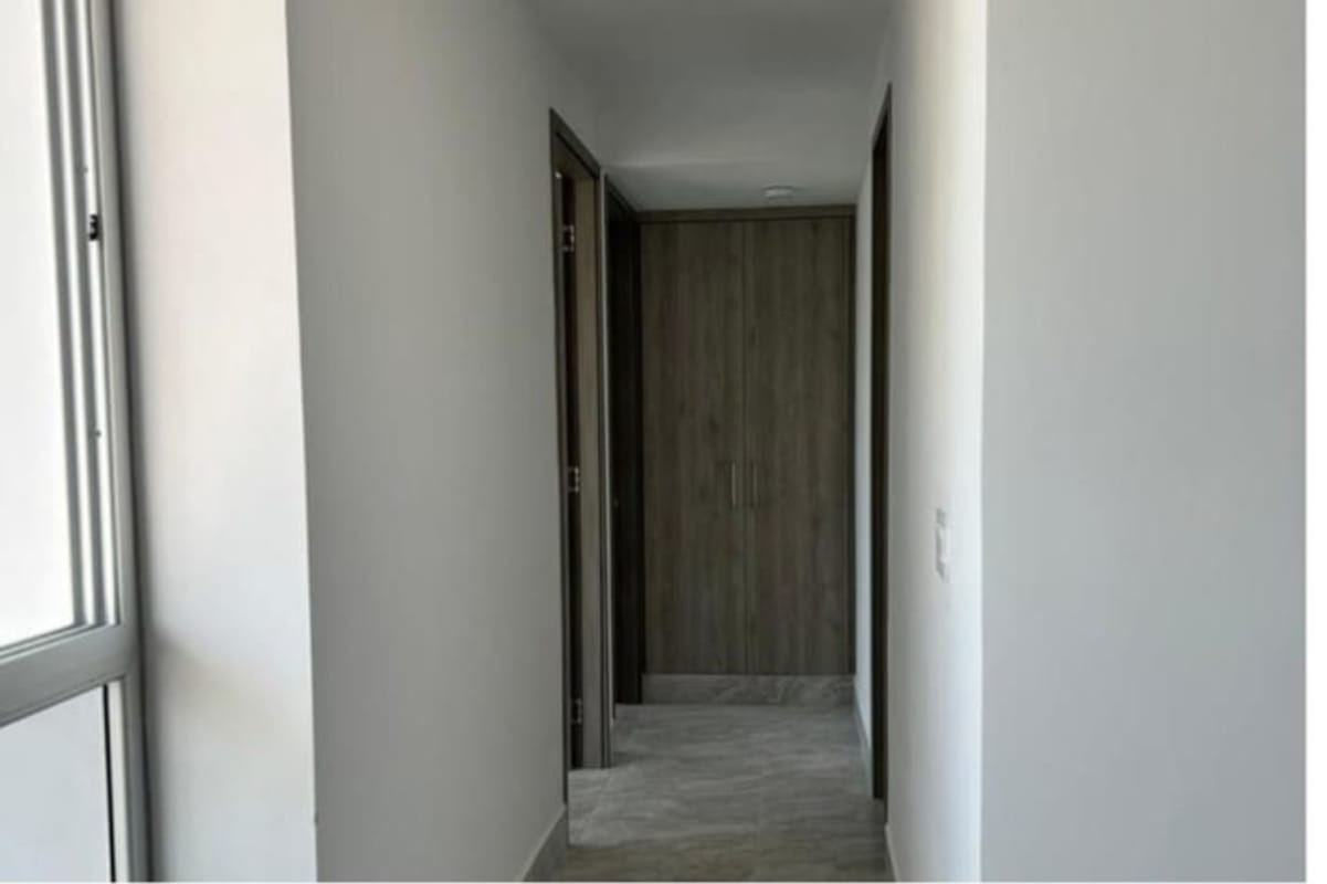 Kitchen with wood grain cabinets, marble tile walls, stainless appliances in PH Luxor 400 El Cangrejo