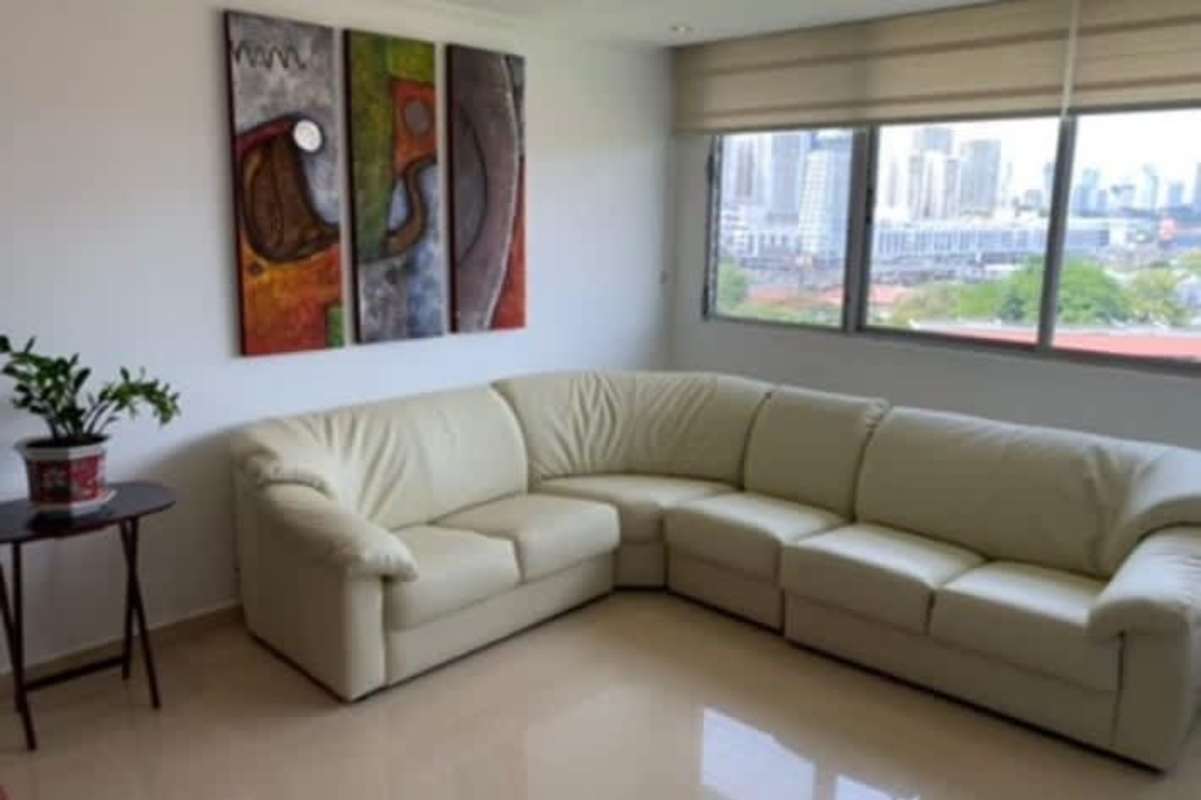 Furnished living and dining open plan with sectional sofa, large windows at PH La Alameda Betania Panama City