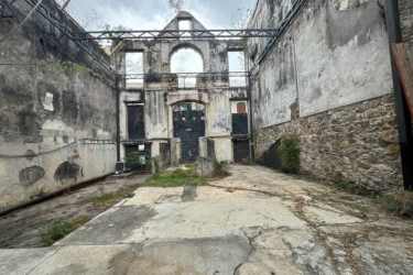 Historic exposed stone walls and arched window openings amid vegetation Casco Viejo Panama