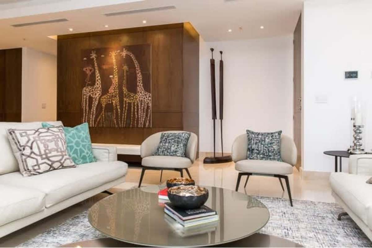 Contemporary living room with wood accents giraffe art cream furniture PH Apogeo Costa del Este