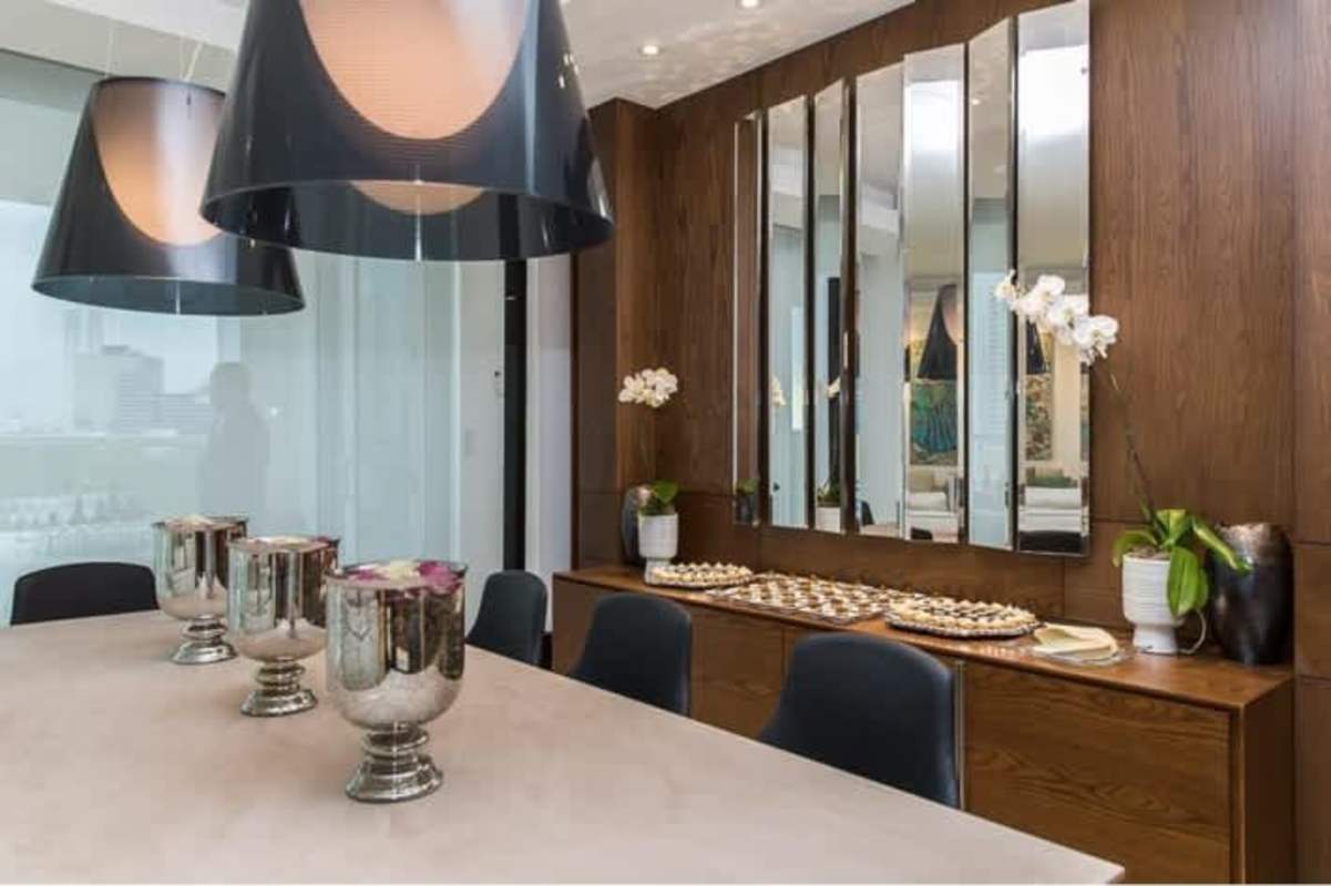 Modern dining area with wood-paneled mirrored wall in PH Apogeo Costa del Este luxury condo