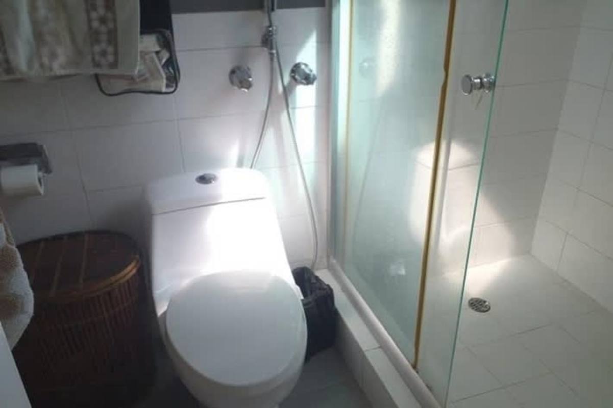 Compact bathroom with glass shower and laundry basket PH San Francisco Bay Panama City