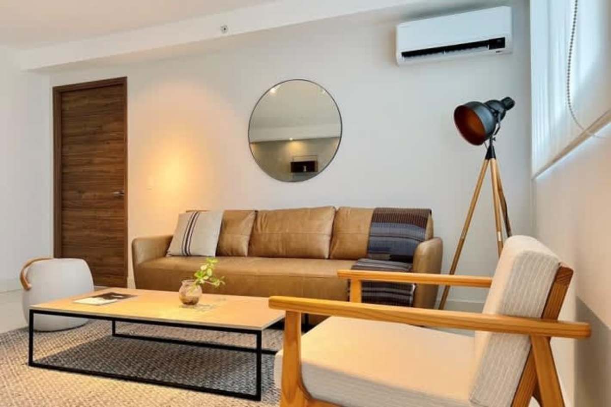 Modern living room with tan leather sofa, window and minimalist decor in PH Isabella Panama