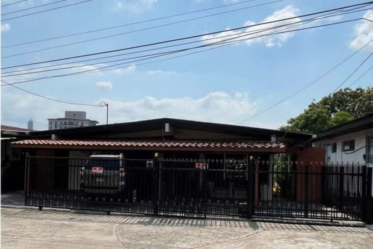 Kitchen with wooden cabinets and tile counters inside Betania house for sale Panama