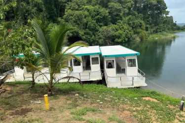 Floating eco houses anchored along rainforest shoreline on Gatun Lake Panama