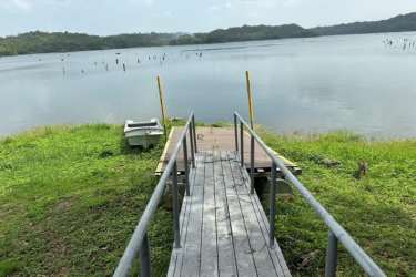 Wood pier extending into calm Lake Gatun for private boat and kayak launches