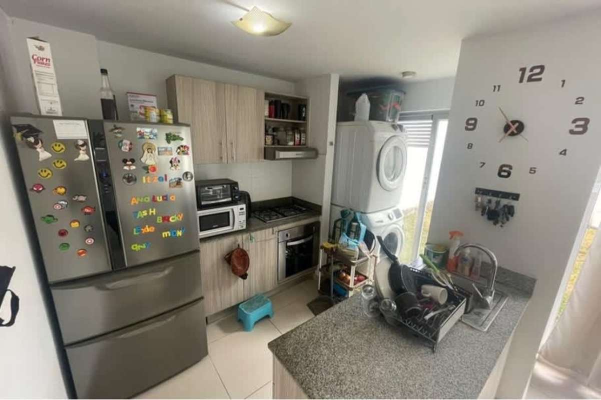 Open kitchen with granite countertops, gas stove, and laundry appliances Villasol Panama