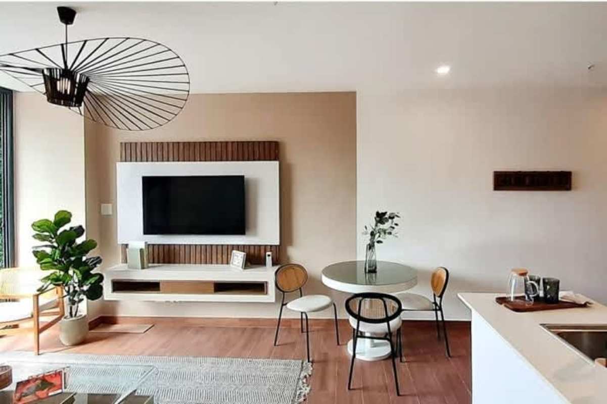 Open-plan living dining room with media wall, pendant light, wood accent in PH Sky Swiss El Cangrejo