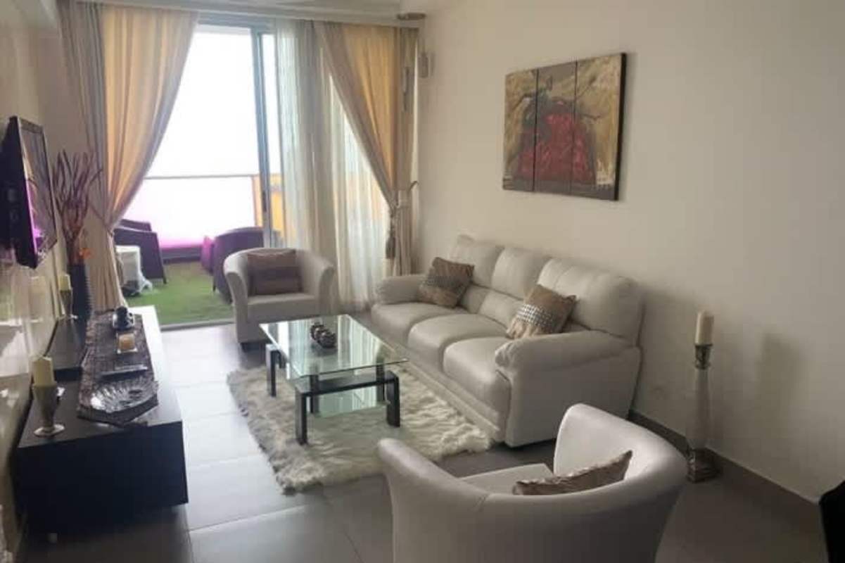 Cozy modern living area leading to ocean-view balcony in PH BICSA Torre Avenida Balboa Panama City