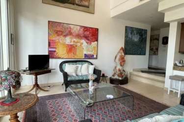 Elegant living room with large windows opening to covered terrace and private pool