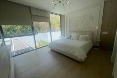 Bedroom featuring large windows, garden view, and modern design at Panama Pacifico home