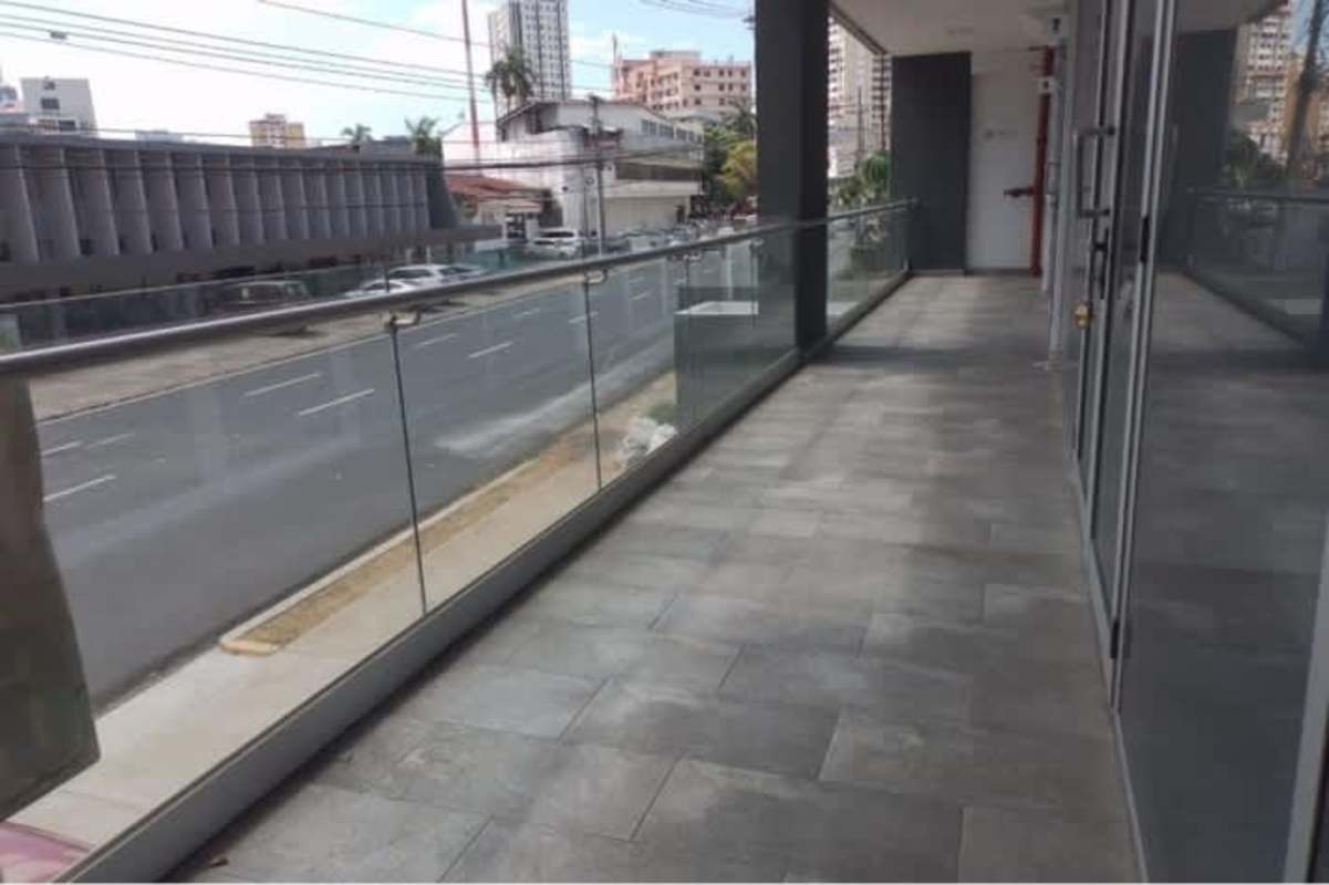 Modern balcony with glass railing overlooking downtown urban street from Signature Point tower Panama