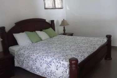 Bedroom with wood bed, nightstands and white walls in Coronado Panama house