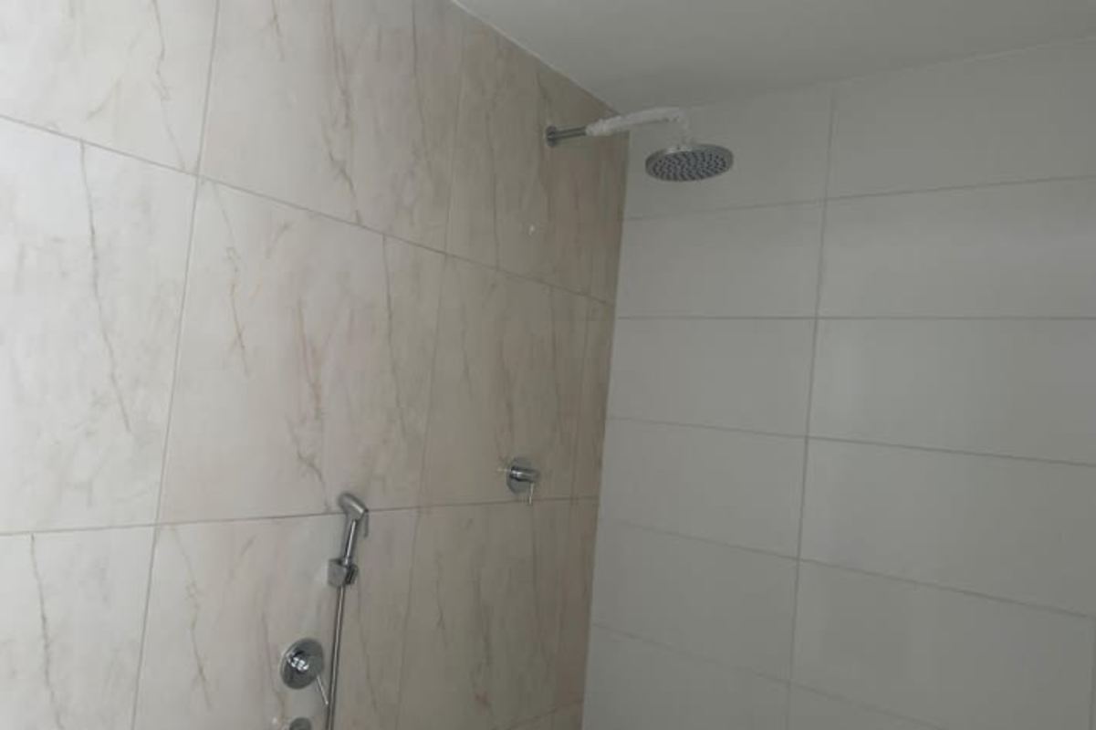 Bathroom with marble-look tiles, glass shower enclosure, and modern vanity at The Sands Panama City