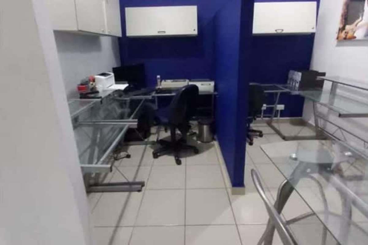 Small office with glass desks blue accent wall mounted cabinets Hi-Tech Plaza