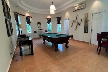 Spacious game room with pool table, arched windows and tiled floor in Coronado luxury mansion