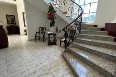 Entrance hall with marble floors, ornate staircase and vaulted ceiling in luxury Coronado mansion
