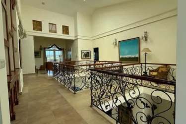 Upper floor corridor Mediterranean style with high ceilings, decorative railing in Coronado mansion