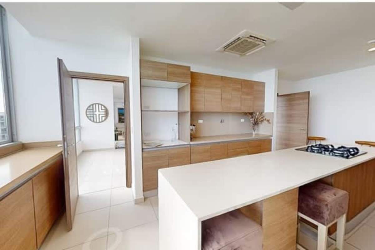 Sleek open kitchen with island and wooden cabinets in PH Costa del Mar apartment