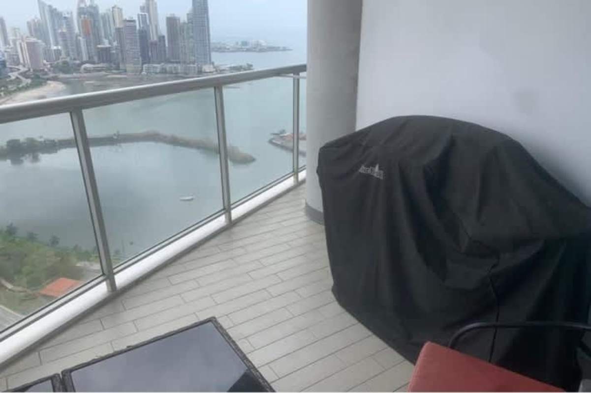 Modern bedroom with large window overlooking Panama City skyline in Yacht Club Tower