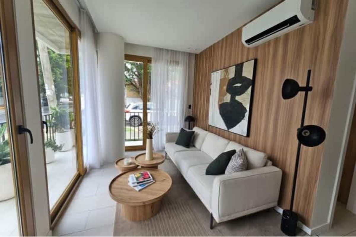 Bright living room open plan with floor-to-ceiling windows and wood accents at PH Bella Vita Panama