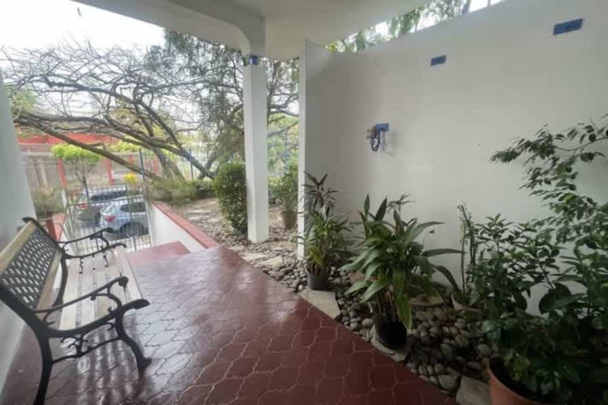 Traditional home office with wooden floors, built-in bookshelves, window in Hato Pintado house Panama City